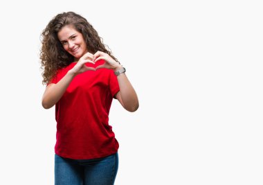 Güzel esmer kıvırcık saçlı Genç kız rahat giyiyor bakmak içinde gülümseyen izole arka plan üzerinde kalp sembolünü gösterirken seviyorum ve elleriyle şekil. Romantik kavramı.