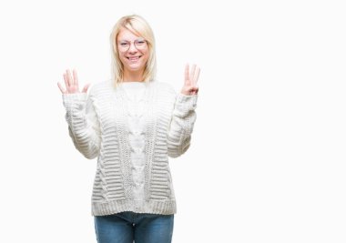 Genç güzel sarışın kadın giyiyor kış kazak ve gözlük gösterilen ve parmakları ile işaret izole arka plan üzerinde kendinden emin ve mutlu gülümseyerek süre sekiz numara.