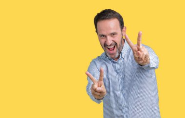 Yakışıklı orta yaş parmak zafer işareti yaparken gösterilen kamera seyir gülümseyen izole arka plan üzerinde zarif komuta sizde. İki numaralı.