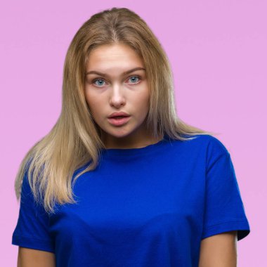 Genç beyaz kadın izole arka plan korkuyor ve sürpriz ifade ile şok yüzünden korku ve yüz heyecanlı.