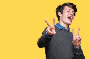 Genç yakışıklı zarif adam zafer işareti yapıyor parmak gösterilen kamera seyir gülümseyen izole arka plan üzerinde. İki numaralı.