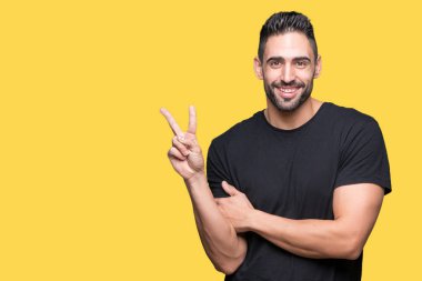 Mutlu yüz zafer işareti yaparken kameraya göz kırpıyor ile gülümseyen izole arka plan üzerinde genç yakışıklı adam. İki numaralı.