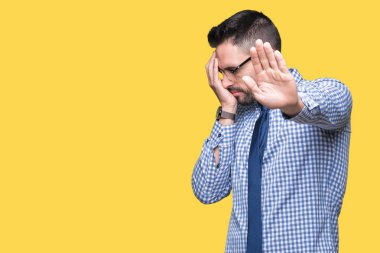 Üzerinde gözlük takan genç iş adamı izole elleriyle gözlerini kapsayan arka plan ve stop jest ile acı ve korku ifadesi. Utandım ve negatif kavramı.
