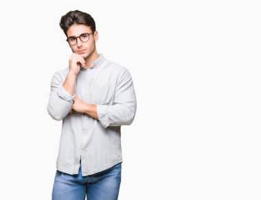 Çene düşünme hakkında soru, dalgın ifade üzerine el ile izole arka plan üzerinde gözlük takan yakışıklı delikanlı. Düşünceli yüzüyle gülümsüyor. Şüphe kavramı.