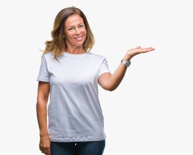 Orta yaş neşeli sunulması ve kameraya bakarak avucunun ile işaret gülümseyen izole arka plan üzerine İspanyol kadın kıdemli.