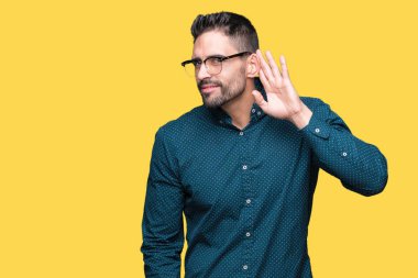 Bir işitme söylenti ya da dedikodu için dinleme kulak üzerinde el ile gülümseyen izole arka plan üzerinde gözlük takan genç yakışıklı iş adamı. Sağırlık kavramı.