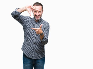 Orta yaş elle yapma çerçeve ve parmakları ile mutlu yüz gülümseyen izole arka plan üzerinde ağarmış komuta sizde. Yaratıcılık ve Fotoğrafçılık kavramı.