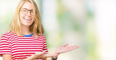 Güzel genç kadın üzerinde gözlük takan izole arka plan el ve reklam mutlu ve kendinden emin gülümseyen sunulması avuç, yanında işaret