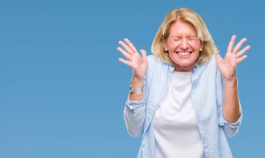 Orta yaş sarışın kadın deli ve silah ile başarı için deli kutluyor izole arka plan üzerinde kaldırdı ve heyecanlı çığlık gözler kapalı. Kazanan kavramı