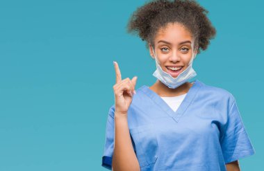 Genç afro Amerikalı doktor kadın başarılı fikirle parmağı yukarıyı izole arka plan yüzünden. Çıktıktan ve mutlu. Bir numara.