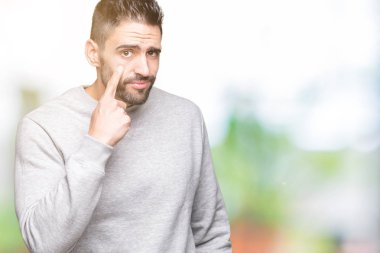 Üzerine tişört giyen genç yakışıklı adam arka plan izole göz izlerken seni jest için şüpheli ifade işaret