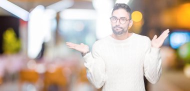 İzole arka plan clueless ve şaşkın bir ifadeyle kollar ve eller kaldırdı üzerinde gözlük takan yakışıklı delikanlı. Şüphe kavramı.