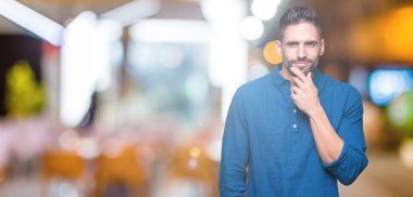 Yakışıklı delikanlı emin çapraz kollar ve çeneme kaldırdı el ile gülümseme ile kameraya bakarak izole arka plan üzerinde. Pozitif düşünce.