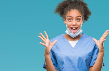Genç afro Amerikalı doktor kadın deli kutluyor arka plan izole ve başarı için kaldırdı kollarını açarak hayrete ve heyecanlı çığlık gözleri açık. Kazanan kavramı