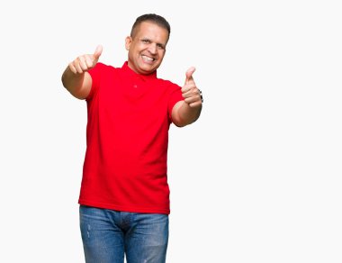 Orta yaş Arap adam el ile pozitif jest yapıyor onaylama izole arka plan üzerinde başparmak gülümseyen ve başarı için mutlu. Kamera, kazanan jest arıyorsunuz.