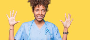 Genç Afro-Amerikan doktor kadın gösterilen ve parmakları ile işaret izole arka plan yüzünden kendinden emin ve mutlu gülümseyerek süre on numara.