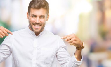 Yüzünde gülümseme ile kendinden emin görünüyorsun, kendini gururlu ve mutlu parmakları ile işaret izole arka plan üzerinde genç yakışıklı adam.