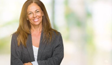 Orta yaş yetişkin kadın giyiyor büyük boy erkek ceket izole arka plan ile bir mutlu ve serin üzerinden yüzündeki gülümseme. Şanslı kişi.