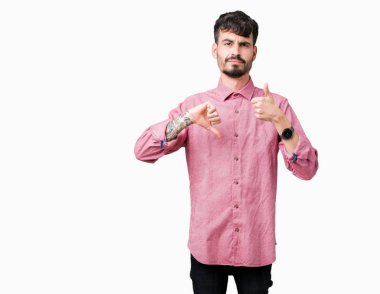 Üzerinde pembe gömlek giymiş genç yakışıklı adam arka plan yapmaya başparmak yukarı ve aşağı anlaşmazlık ve anlaşma ifade izole. Deli çatışma