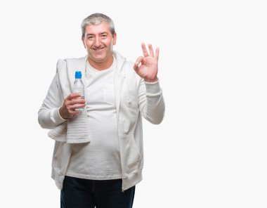 Yakışıklı komuta sizde eğitim holding havlu ve su şişesi üzerinde parmak, mükemmel sembolü ile ok işareti yapıyor izole arka plan