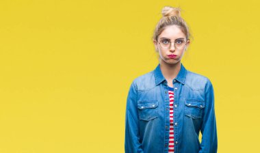 Komik surat ile yanakları şişirme izole arka plan üzerinde gözlük takan genç güzel sarışın bir kadın. Ağız ile hava, deli ifade şişirilmiş.