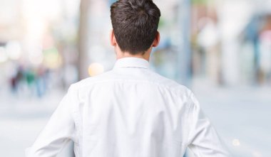 İzole arka plan ayakta geriye doğru uzakta silah ile vücut üzerinde seyir üzerinde gözlük takan genç yakışıklı iş adamı