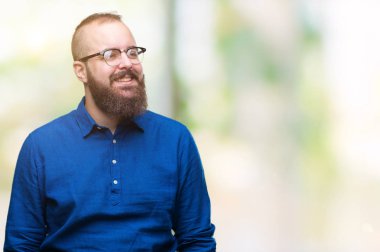 Üzerinde gözlük takan Genç beyaz hipster adam arka plan uzak tarafına gülümseme ile yüzünde, doğal ifade arıyorum izole. Kendine güvenen gülüyor.