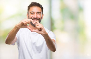 Kalp simgesi ve elleriyle şekil gösterilen aşık gülümseyen izole arka plan yetişkin İspanyol adam. Romantik kavramı.