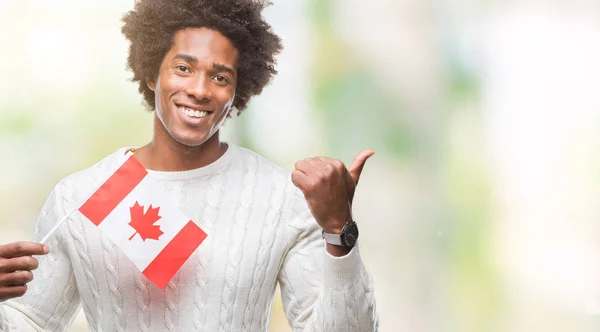 加拿大非洲裔美国人的旗子在被隔绝的背景指向和显示以拇指到边与愉快的面孔微笑 — 图库照片