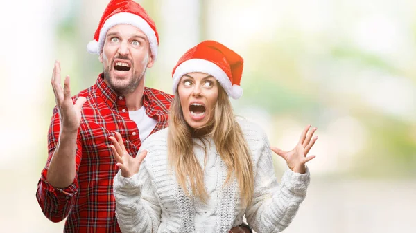 Üzerinde Noel şapka aşık genç çift arka plan çılgın ve kızgın bağırarak ve agresif ifade ve silah kaldırdı bağırmaya izole. Hayal kırıklığı kavramı.