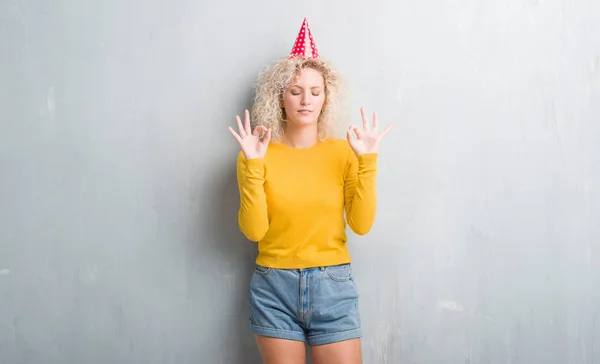 Jovem Loira Sobre Grunge Parede Cinza Usando Chapéu Aniversário Relaxar — Fotografia de Stock