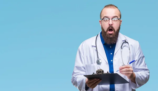 Junger Arzt Hält Klemmbrett Über Isolierten Hintergrund Erschrocken Mit Einem — Stockfoto