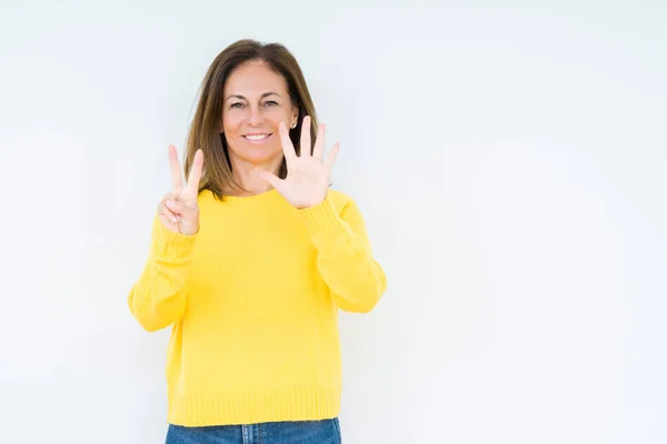 孤立した背景表示と指で上向きに黄色のセーターを着ている美しい中年女性数は自信を持って 幸せな笑みを浮かべている間 — ストック写真