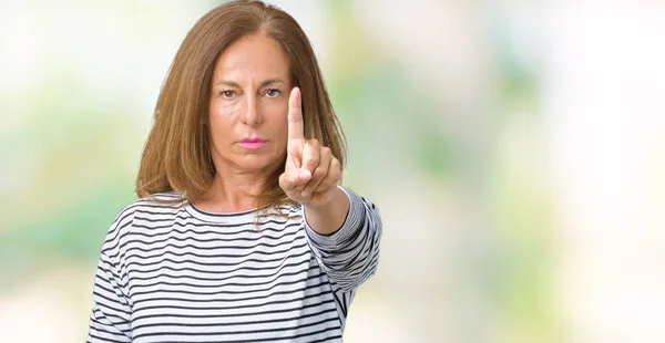 Beautiful middle age woman wearing stripes sweater over isolated background Pointing with finger up and angry expression