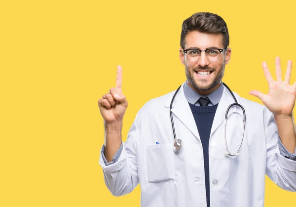 分離背景表示と指で上向きに若いハンサムな医師男性ナンバー 自信を持って 幸せな笑みを浮かべて — ストック写真