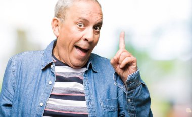 Denim ceket işaret parmağı ile başarılı fikir giymiş yakışıklı komuta sizde. Çıktıktan ve mutlu. Bir numara.