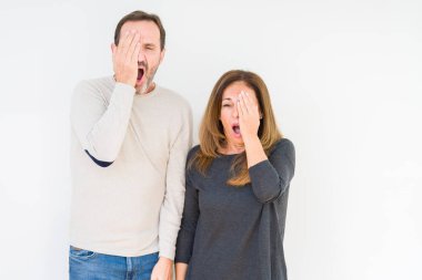 Güzel orta yaş kaç aşk yorgun esneme izole arka plan üzerinde içinde yarım yüz, göz ve ağız el ile kapsayan. Acı yüzü acıyor.