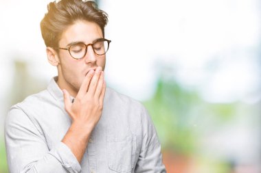 Yakışıklı delikanlı izole arka plan üzerinde gözlük el ağzıyla kapsayan yorgun esneme sıkılmış. Restless ve uyku hali.