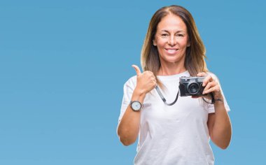 Orta yaş vintage fotoğraf makinesi izole arka plan üzerinde mutlu ok işareti yapıyor büyük gülümseme ile kullanarak fotoğraf çekimi İspanyol kadın parmakları ile mükemmel işaret parmak