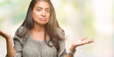 Genç güzel Arap kadın izole arka plan clueless ve şaşkın bir ifadeyle kollar ve eller kaldırdı. Şüphe kavramı.