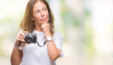 Orta yaş İspanyol kadın üzerinde Vintage Fotoğraf kamera ile fotoğraf çekmek hakkında soru, çok karışık fikir arka plan ciddi bir yüz düşünme izole