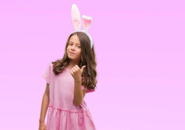 Esmer Latin kız ok işareti, başparmak ile parmak, mükemmel işareti yapıyor kocaman bir gülümseme ile Paskalya tavşan kulakları mutlu giyiyor