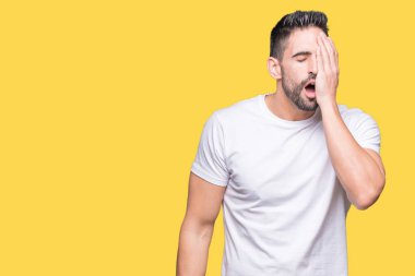 Yakışıklı adam yarım yüz, göz ve ağız el ile kapsayan yorgun esneme sarı izole arka plan üzerinde beyaz t-shirt giyiyor. Acı yüzü acıyor.