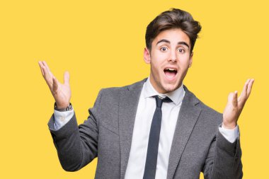 Giyen genç iş adamı uygun ve çılgın ve çığlık kaldırdı ve açık gözleri heyecanlı silah ile başarı için hayran kutluyor izole arka plan üzerinde kravat. Kazanan kavramı