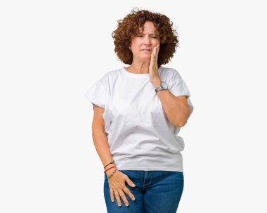 Diş ağrısı veya dişlerde dişlerle ilgili hastalık nedeniyle ağız acı ifadesi ile el ile dokunmak izole arka plan üzerinde beyaz t-shirt giyen güzel orta ager kadın kıdemli. Diş hekimi kavramı.