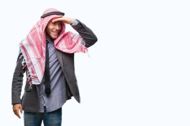 Uzun saçlı keffiyeh üzerinde giyen genç yakışıklı Arap adam arka plan çok mutlu ve gülümseyen uzakta el ile üzerine kafa seyir izole. Arama kavramı.