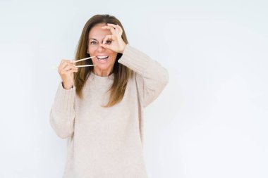 Asya yemek çubukları ile mutlu yüz el parmaklarının arasından seyir göz üzerinde ok işaretiyle yapıyor gülümseyen izole arka plan üzerinde tutan orta yaş kadın