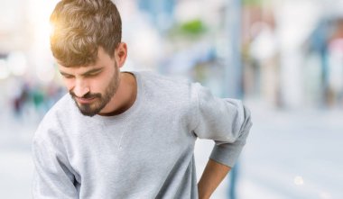 Genç yakışıklı adam giyen kazak izole üzerinde arka plan geri el ile kas ağrısı dokunmadan acı sırt ağrısı,