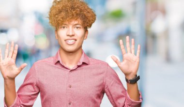 Gösterilen ve parmakları ile işaret afro saçlı Genç yakışıklı iş adamı kendinden emin ve mutlu gülümseyerek süre on numara.