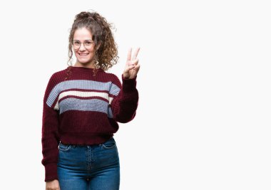 Güzel esmer kıvırcık saçlı Genç kız üzerinde gözlük takan gösterilen arka plan izole ve parmakları ile işaret kendinden emin ve mutlu gülümseyerek ise ikinci.